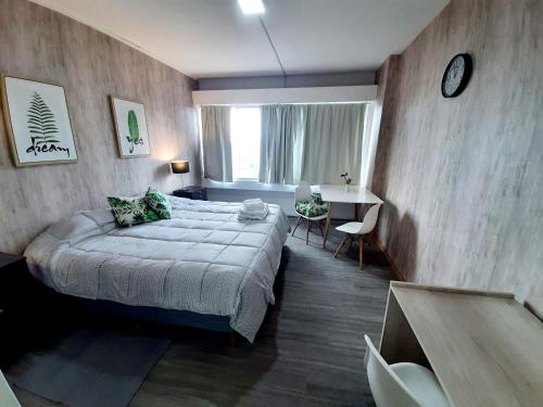 Un dormitorio con una cama, una mesa y un escritorio. en Center 208 - DAT (Habilitación 170/2018), en San Carlos de Bariloche