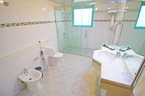 a bathroom with a toilet and a sink and a shower at The George Hotel by Saffron, Dubai Creek in Dubai