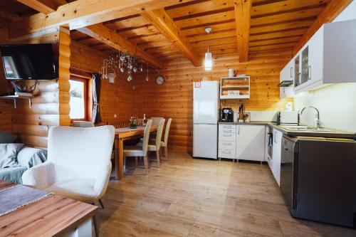 - une cuisine et une salle à manger avec une table dans une cabine dans l'établissement Chata pod Kyčerou, à Terchová