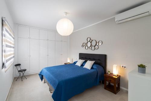 a bedroom with a blue bed with a blue blanket at Villa Papagayo Deluxe by Villa Plus in Corralejo