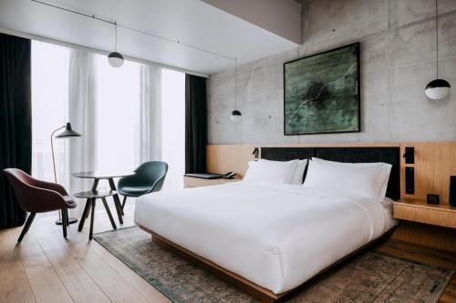 sypialnia z dużym białym łóżkiem i stołem w obiekcie Nobu Hotel Warsaw w Warszawie
