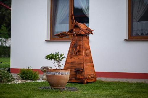 a wooden windmill sitting outside of a house at Domčeky Sabinka a Melinka in Valča