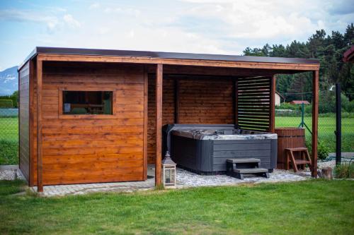 a wooden shed with a hot tub in the grass at Domčeky Sabinka a Melinka in Valča