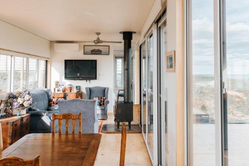 a living room with a couch and a table at One Tree Hill Wilson prom and Ocean views in Toora