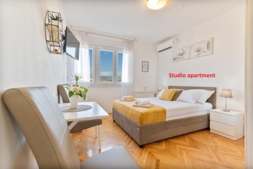 ein Schlafzimmer mit einem Bett, einem Tisch und einem Stuhl in der Unterkunft Apartments Plokite in Split