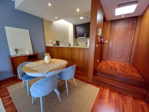 a dining room with a table and blue chairs at Cabedelo Beach Apartment in Viana do Castelo