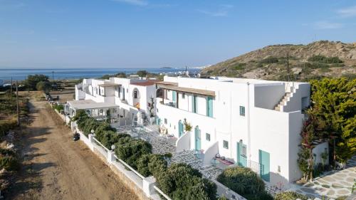 una fila de casas blancas con el océano en el fondo en Naxos Cave Suites, en Stelida