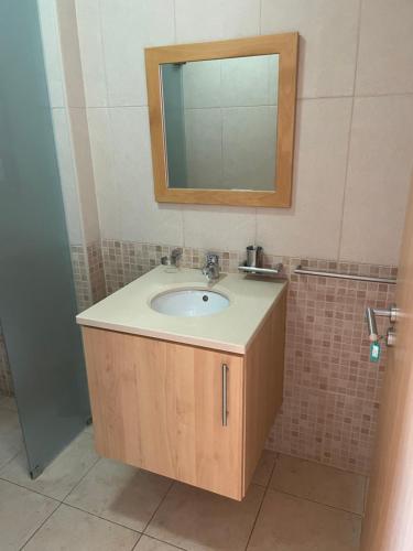 a bathroom with a sink and a mirror at T1 Apartment Cabanas in Cabanas de Tavira