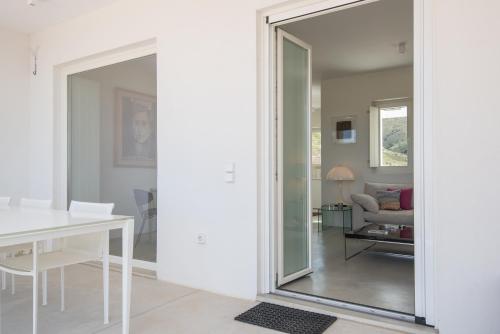 a pivot door in a living room with a mirror at Noble 7 Suites - Adults Only - Onar Hotels Collection in Parikia