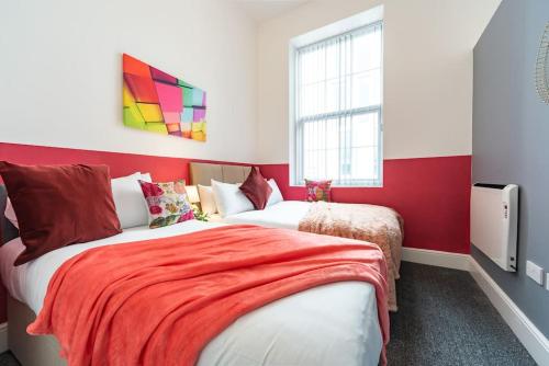 a bedroom with two beds with red and white walls at Jesouth Gorgeous Inn Striking Splashy Flashy Wifi in Hull