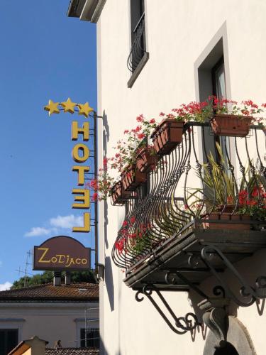 a flower basket on the side of a building with flowers at Hotel Zodiaco in Bolsena