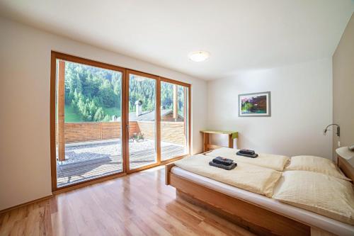 1 dormitorio con cama y ventana grande en Pritscheshof Ferienwohnung Terrasse, en Malles Venosta