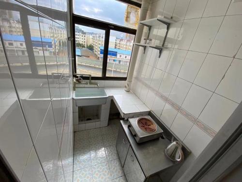 a bathroom with a shower and a sink and a window at 七零四 in Kunming