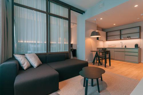 a living room with a couch and a table and a kitchen at Original Sokos Hotel Seurahuone Savonlinna in Savonlinna