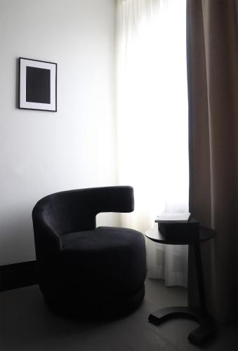 a black chair sitting in front of a window at Hotel National Antwerp in Antwerp