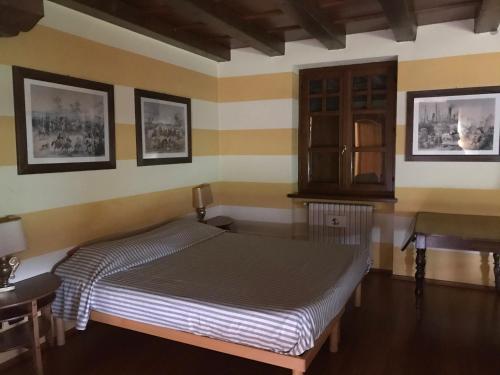 een slaapkamer met een bed, een tafel en een wastafel bij B&B IL CASTELLETTO in Pinerolo