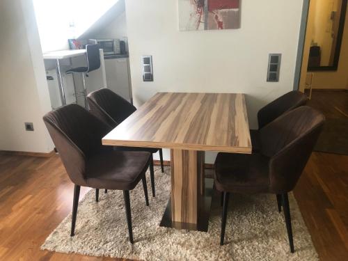 uma mesa de jantar com quatro cadeiras à volta em Klagenfurt`s Loft em Klagenfurt