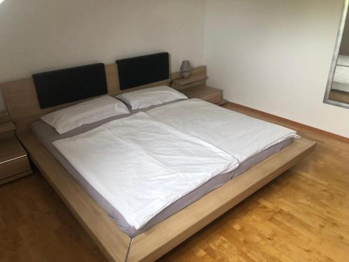 a large bed in a bedroom with white sheets at Klagenfurt`s Loft in Klagenfurt