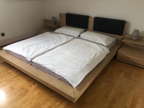 1 dormitorio con 1 cama grande con sábanas y almohadas blancas en Klagenfurt`s Loft, en Klagenfurt