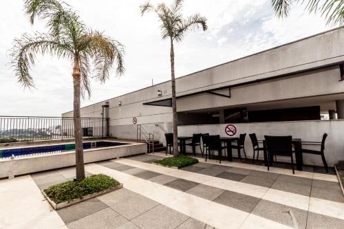 un patio avec une table et des palmiers dans un bâtiment dans l'établissement 360 Expo Center, à São Paulo