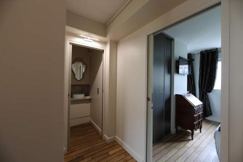 a hallway with a door to a bathroom with a mirror at Superbe appartement face à la baie au Crotoy in Le Crotoy