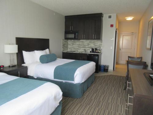 a hotel room with two beds and a kitchen at Best Western Plus Airdrie Gateway in Airdrie