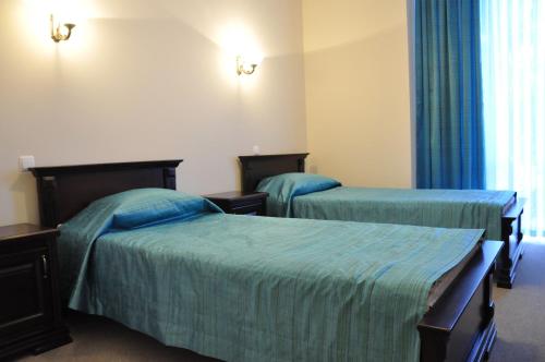 a hotel room with two beds with blue sheets at Hotel-Restaurant Complex Vensky in Brovary