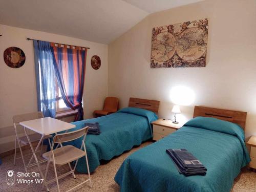 Habitación de hotel con 2 camas, mesa y sillas en BeB Infamiglia, en Cascinette