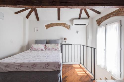 a white bedroom with a bed and two windows at Appartamento San Martino by Wonderful Italy in Bologna