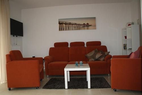 a living room with two couches and a table at Frida in Norddeich