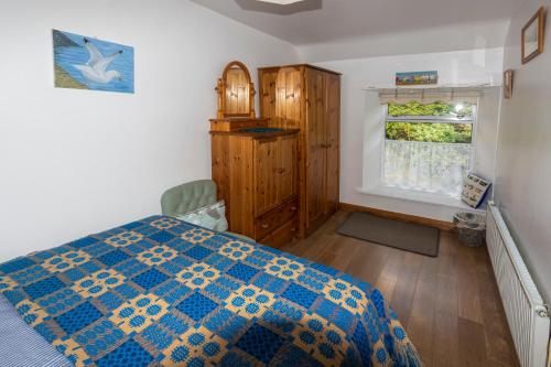 a bedroom with a bed and a window at Thorn cottage in Fishguard