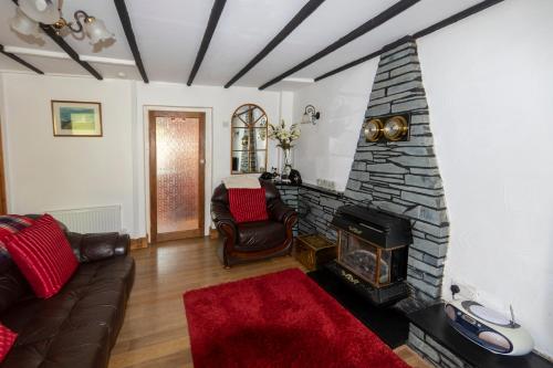 a living room with a couch and a fireplace at Thorn cottage in Fishguard
