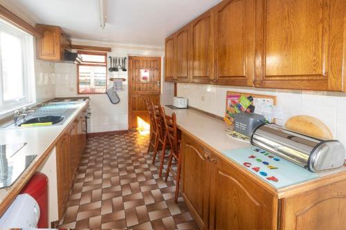 a kitchen with wooden cabinets and a counter top at Thorn cottage in Fishguard