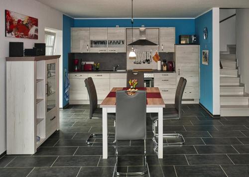 a kitchen with a table and chairs and blue walls at GrachtenGlück in Greetsiel