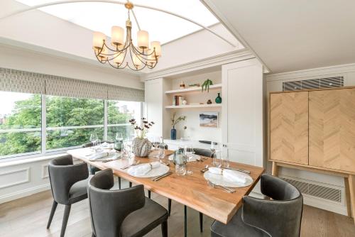 a dining room with a table and chairs and a chandelier at Buckingham & Lloyds in London