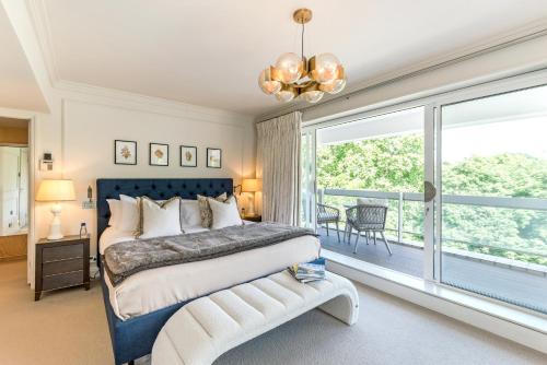 a bedroom with a bed and a large window at Buckingham & Lloyds in London