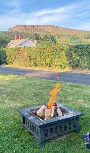 a fire pit in the middle of a field at Swanns Bridge Glamping in Limavady