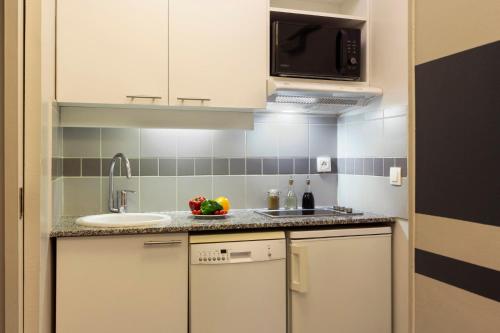 a small kitchen with a sink and a microwave at Citadines City Centre Lille in Lille