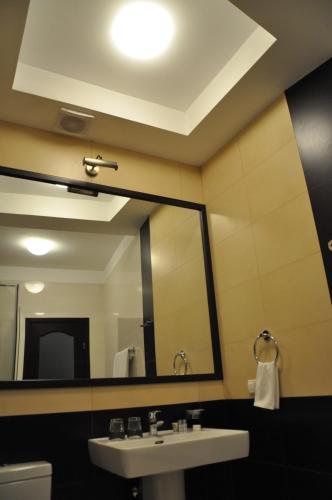 a bathroom with a sink and a large mirror at Hotel-Restaurant Complex Vensky in Brovary