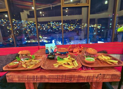 two cutting boards with hamburgers and french fries on a table at ISKAY BOUTIQUE HOSTEL in La Paz