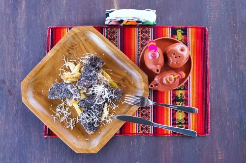 a plate of food on a table with a fork and knife at ISKAY BOUTIQUE HOSTEL in La Paz
