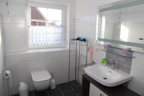 a bathroom with a sink and a toilet and a window at Ruth in Warin
