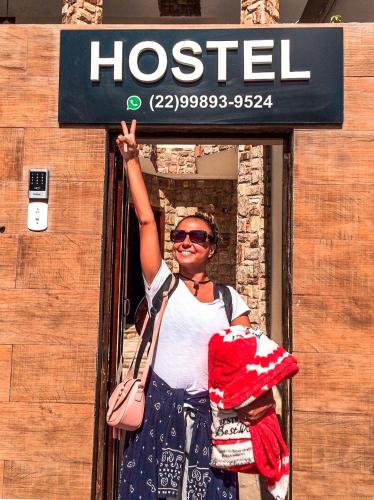アハイアウ・ド・カボにあるVarandas do Arraial- Hostelの女が看板を持っている