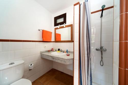 Un baño con lavabo, inodoro y espejo. en Villa Papagayo by Villa Plus, en Playa Blanca