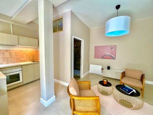 une cuisine et un salon avec une table et des chaises dans l'établissement Suite Monceau - Reims, à Reims