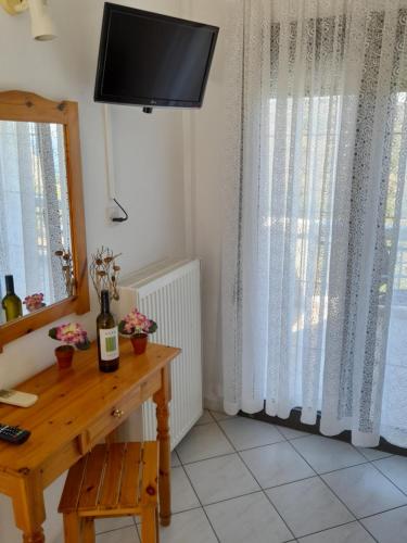 a room with a table and a television on a wall at Giola aparments and studios 2 in Astris