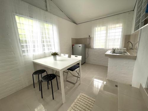 a kitchen with a white table and two chairs at Cosy little home near to the town in Pasir Puteh
