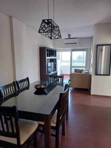 a dining room and living room with a table and chairs at DEPTO CENTRICO CON COCHERA EN CORRIENTES-Las Leonoras- in Corrientes