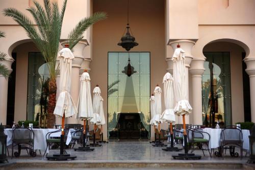 a group of tables and chairs with white umbrellas at Pickalbatros The Palace Port Ghalib in Port Ghalib