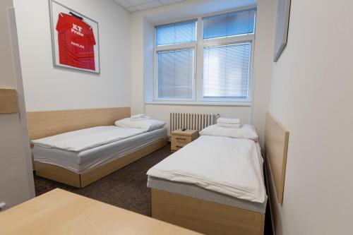 Cette chambre comprend 2 lits et une fenêtre. dans l'établissement Arena Apartments, à Havlíčkův Brod